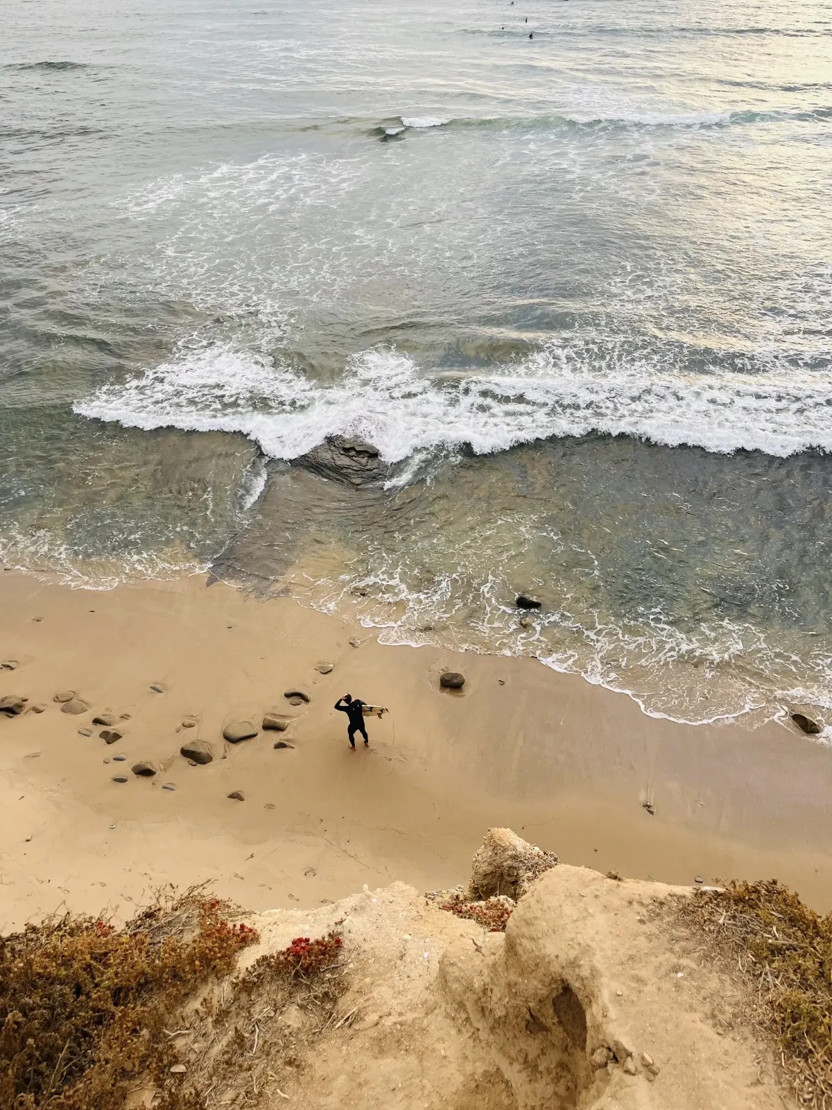 Waves meeting the shore beneath the cliffs in San Diego