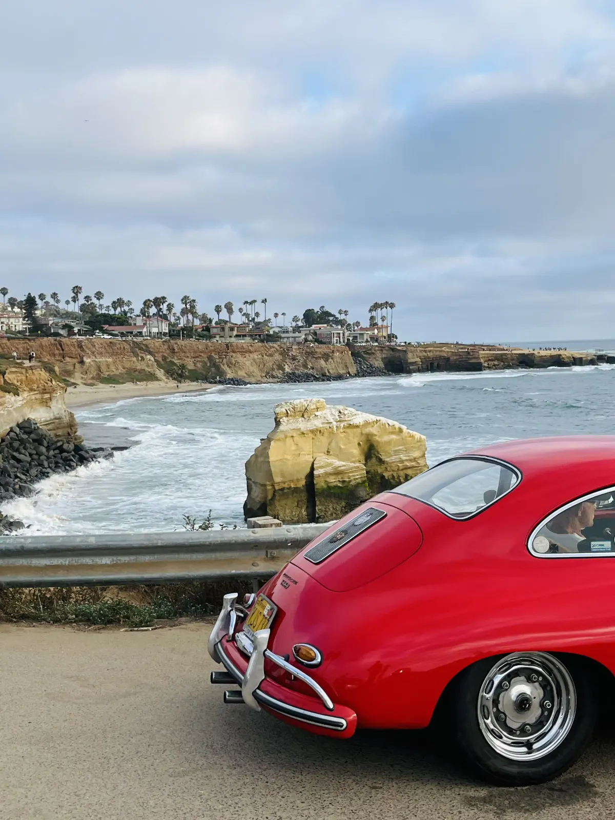 A red classic car overlooking the San Diego coast