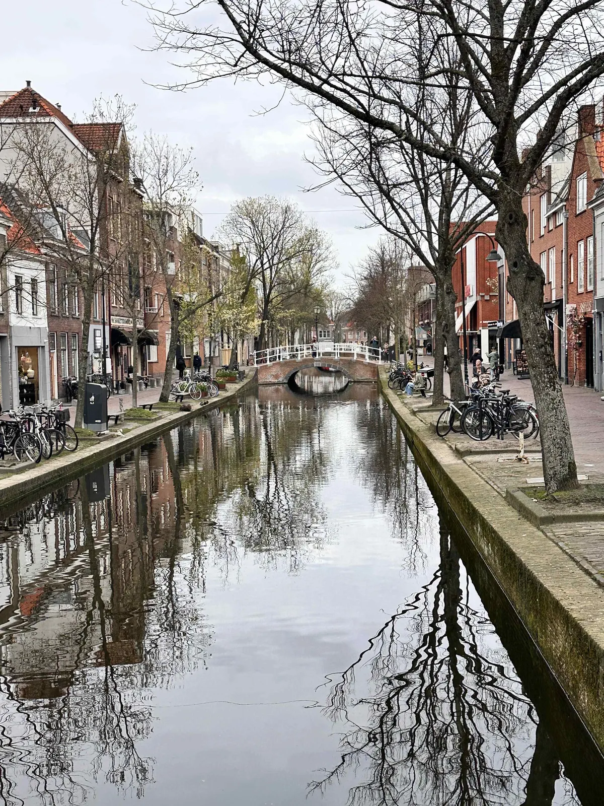 A canal street in Delft with bicycles and historic buildings