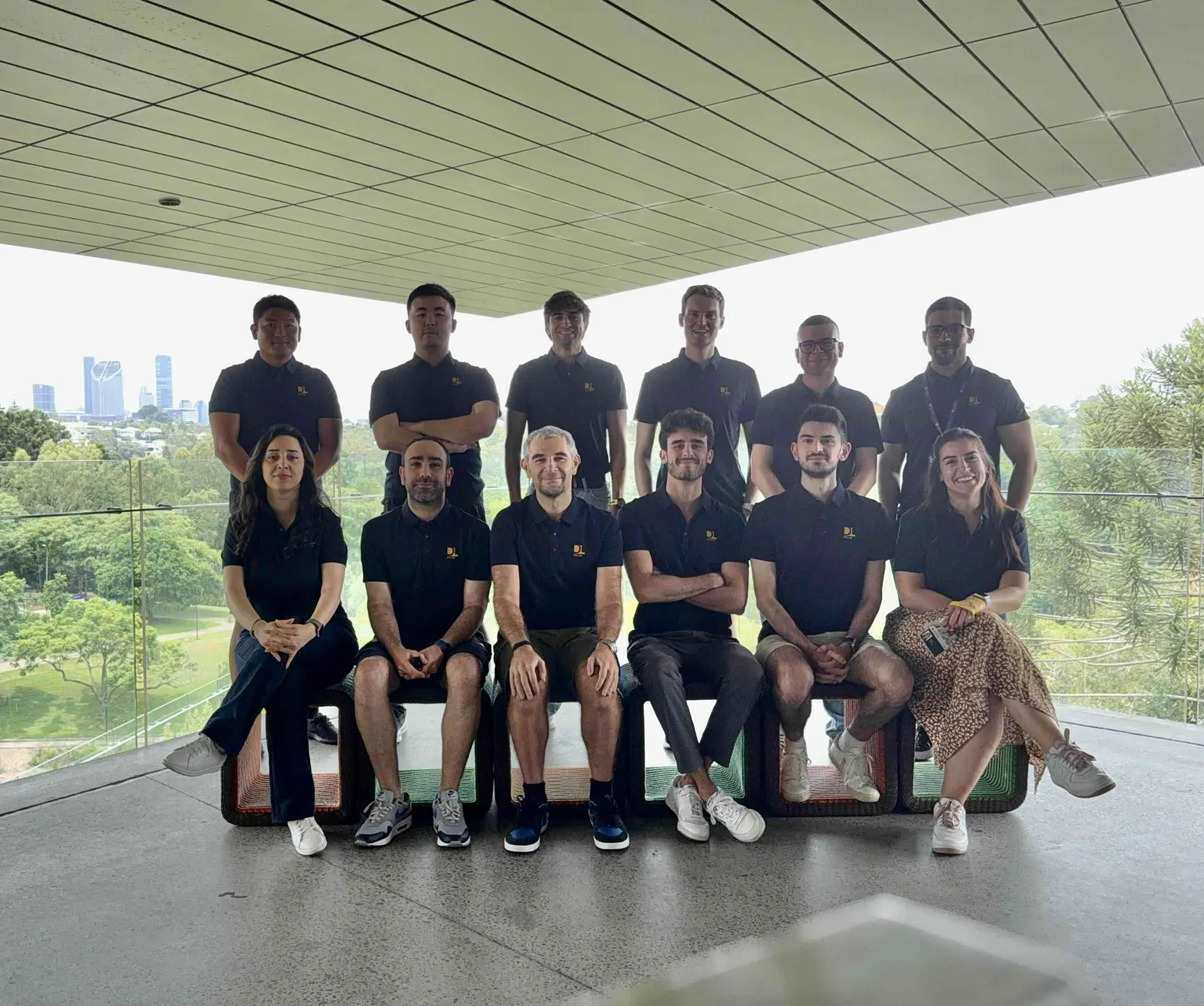 DLab members in two rows on a covered terrace overlooking Brisbane